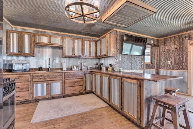 3142 Fishin Hole Rd, Flemington, MO 65650 - kitchen with wood walls, a sink, light wood-style floors, and gas range