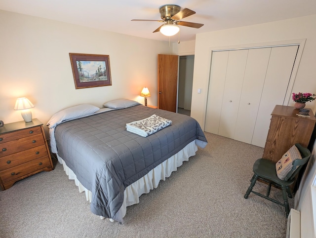 carpeted bedroom featuring ceiling fan and a closet