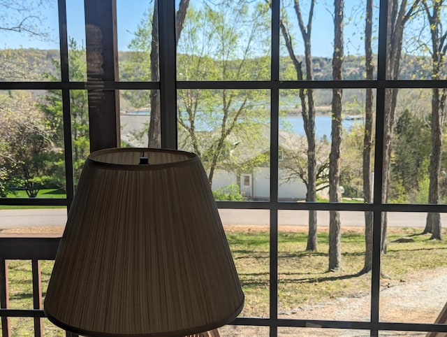 unfurnished sunroom featuring a water view and a hot tub