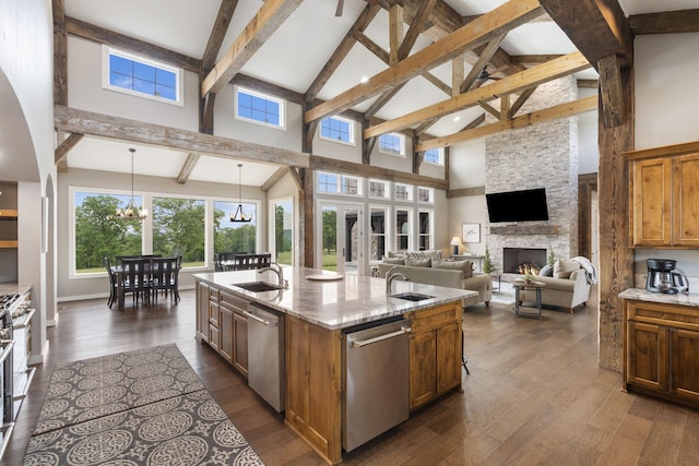 395 Tracy St, Branson, MO 65616 - kitchen with high vaulted ceiling, stainless steel dishwasher, a sink, brown cabinets, and a fireplace