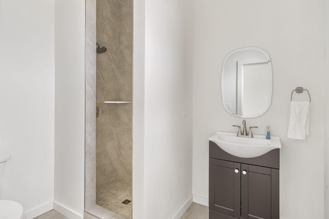 bathroom with vanity, toilet, and tiled shower