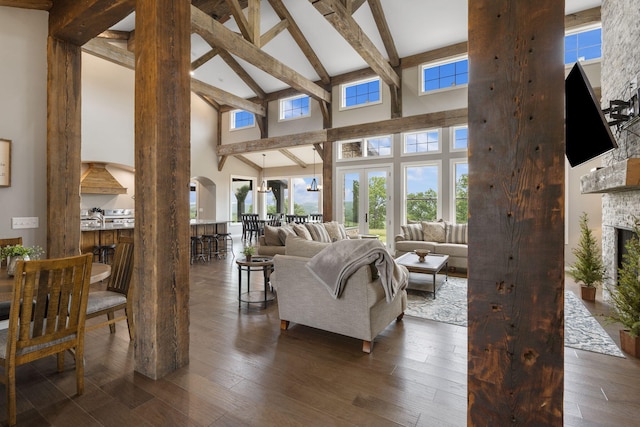 living room with a brick fireplace, high vaulted ceiling, beamed ceiling, and dark hardwood / wood-style flooring