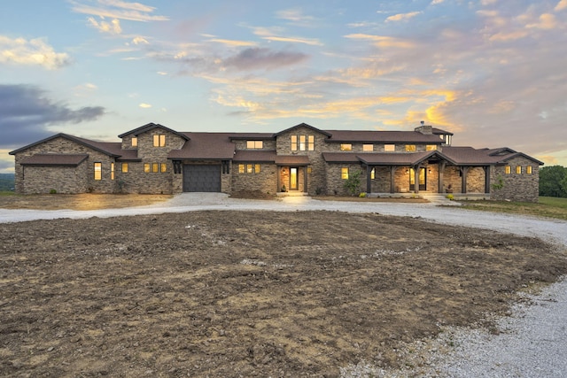 395 Tracy St, Branson, MO 65616 - prairie-style home with an attached garage, covered porch, and curved driveway
