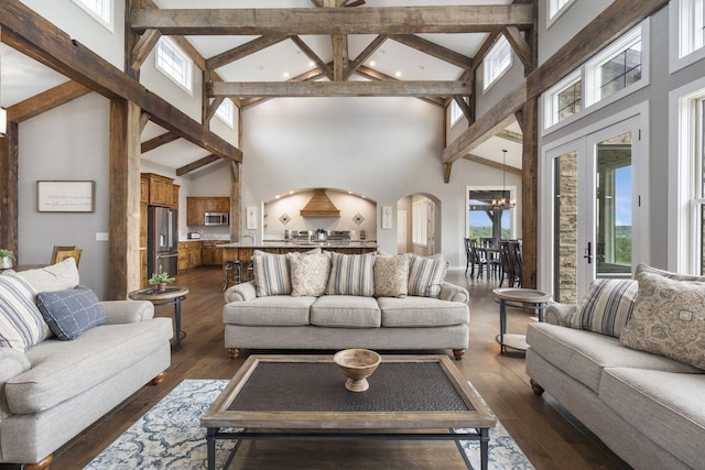 living room with dark hardwood / wood-style floors, high vaulted ceiling, and a healthy amount of sunlight