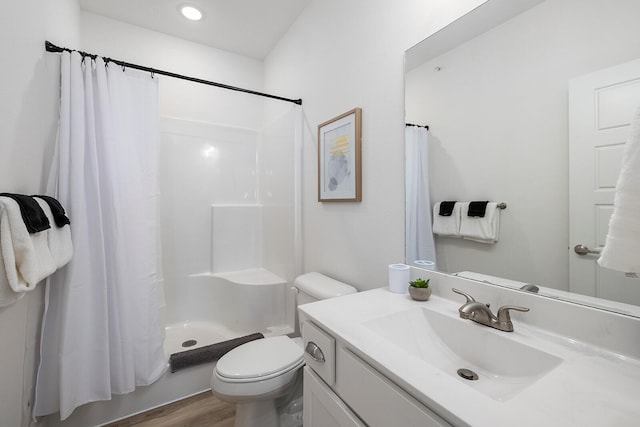 bathroom with hardwood / wood-style floors, toilet, a shower with curtain, and vanity