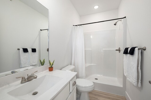 bathroom with curtained shower, hardwood / wood-style floors, vanity, and toilet