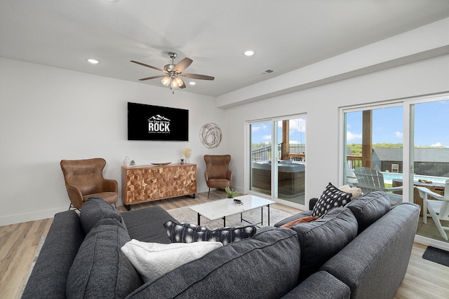 living room with light wood-type flooring and ceiling fan