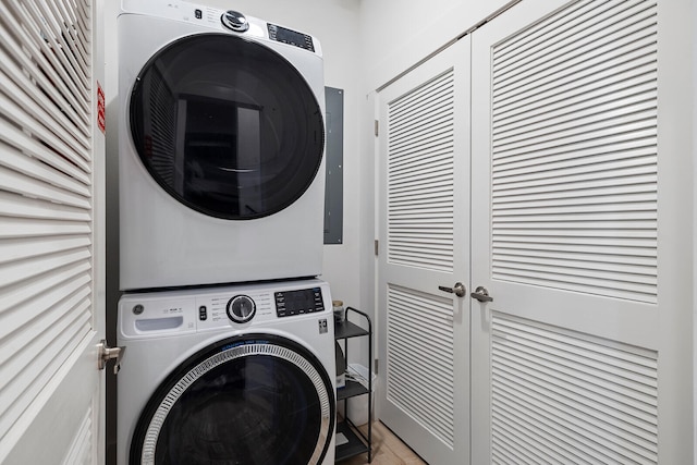 washroom with cabinets and stacked washer / drying machine