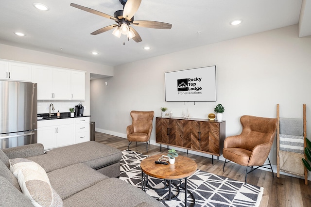 living room with dark wood-type flooring, sink, and ceiling fan