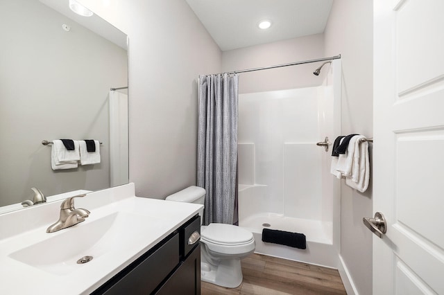 bathroom featuring hardwood / wood-style flooring, toilet, curtained shower, and vanity