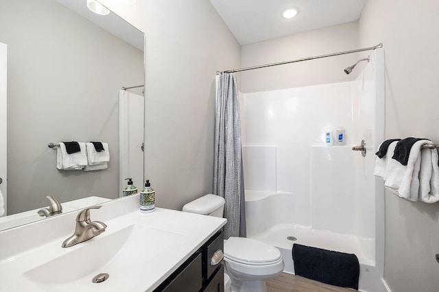 bathroom with wood-type flooring, vanity, toilet, and a shower with shower curtain