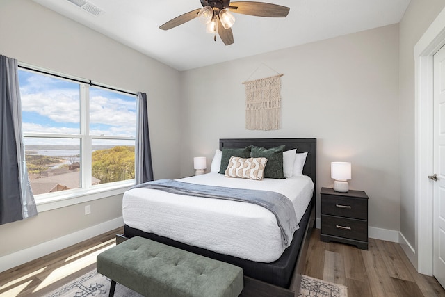 bedroom with light hardwood / wood-style floors and ceiling fan