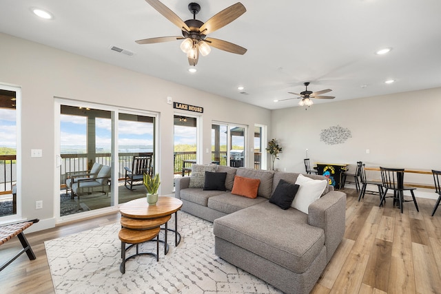 living room with ceiling fan, light hardwood / wood-style flooring, and a healthy amount of sunlight