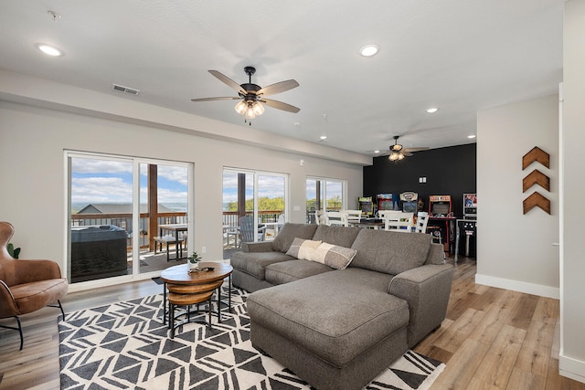 living room featuring light wood-type flooring and ceiling fan