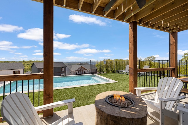 view of pool featuring a fire pit, a lawn, and a patio area