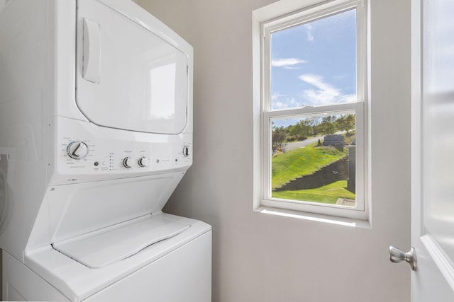 washroom featuring stacked washer / drying machine and laundry area