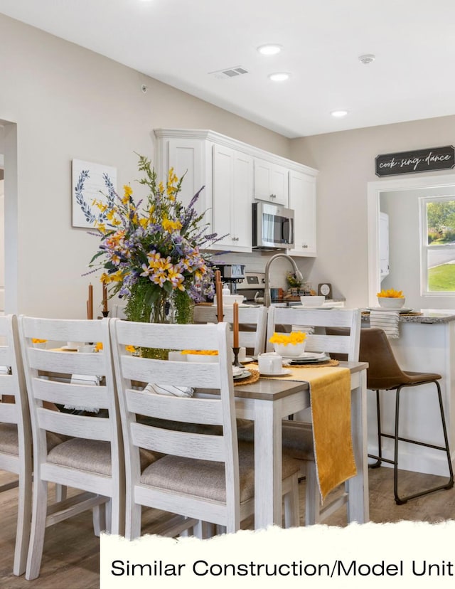 kitchen featuring dark hardwood / wood-style floors, stainless steel appliances, and white cabinets