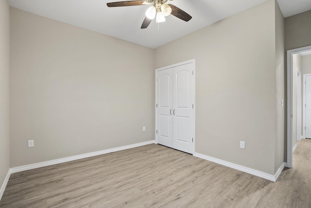 unfurnished bedroom with baseboards, a ceiling fan, light wood-style floors, and a closet
