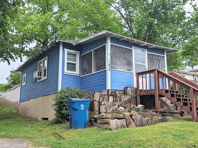 exterior space with cooling unit, a yard, a sunroom, and a wooden deck