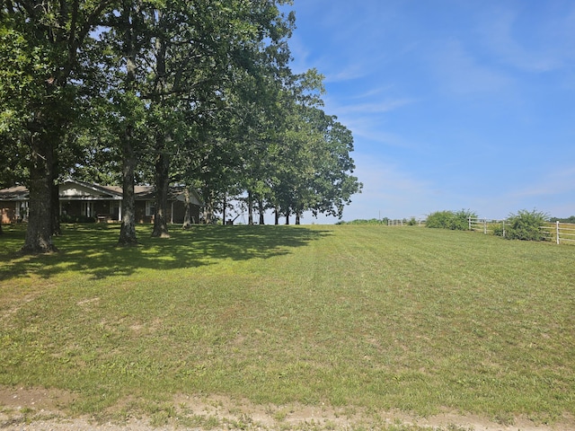 view of yard featuring fence and a rural view