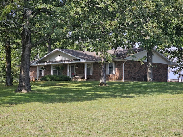 ranch-style home with a front lawn, brick siding, and covered porch