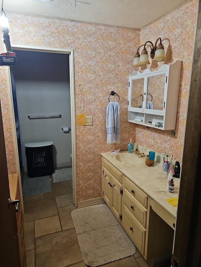 bathroom featuring wallpapered walls, tile patterned floors, toilet, vanity, and a textured ceiling
