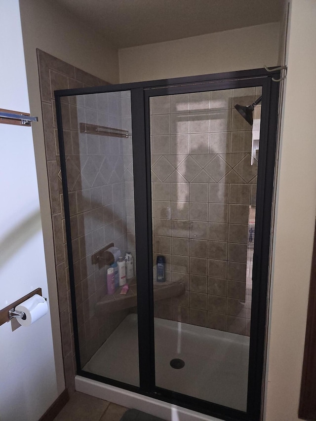 full bath with tile patterned floors and a stall shower