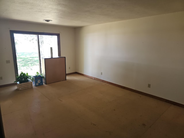 spare room with a textured ceiling, baseboards, and visible vents