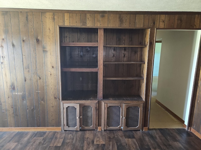 interior details with wood finished floors, wooden walls, and baseboards