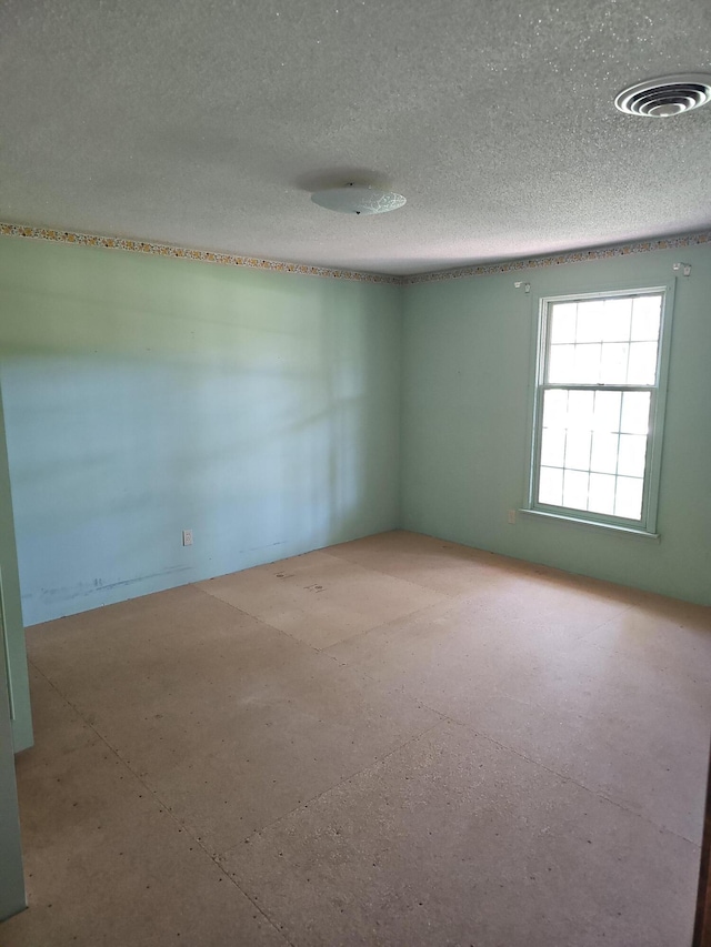 empty room featuring a textured ceiling and visible vents