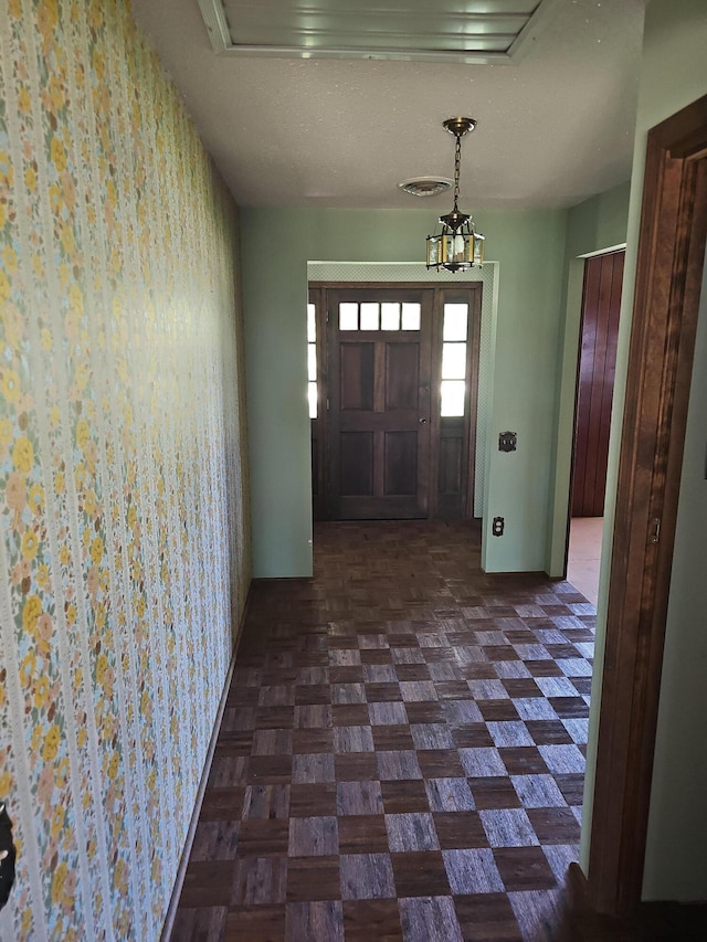 entrance foyer with visible vents, wallpapered walls, and baseboards