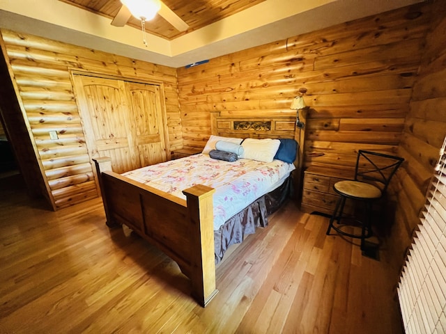 bedroom featuring hardwood / wood-style flooring, wooden ceiling, a ceiling fan, and a tray ceiling