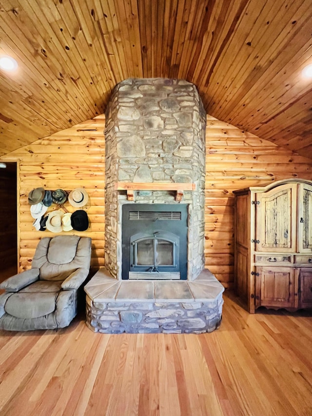unfurnished living room with wood ceiling, lofted ceiling, rustic walls, and a fireplace