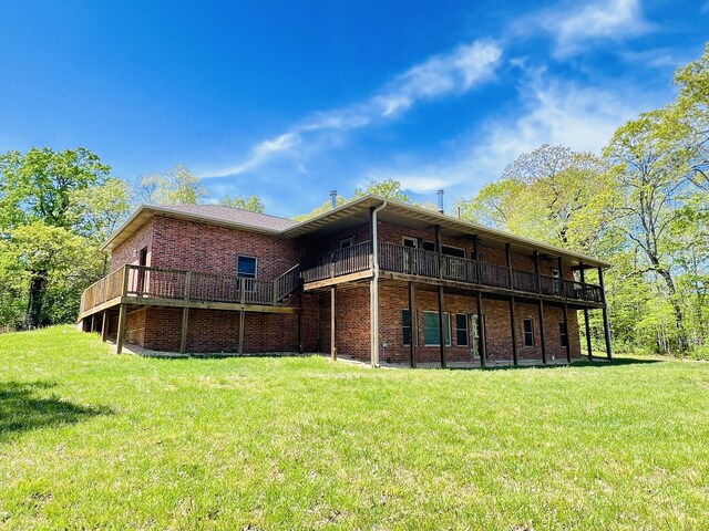 back of house with brick siding, a lawn, and a wooden deck