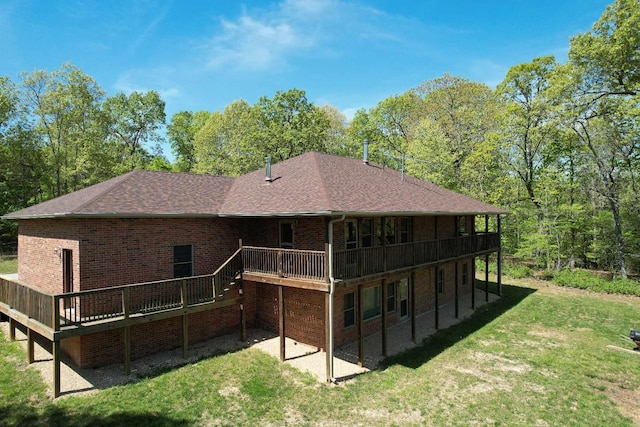 back of house featuring a wooden deck, brick siding, and a yard