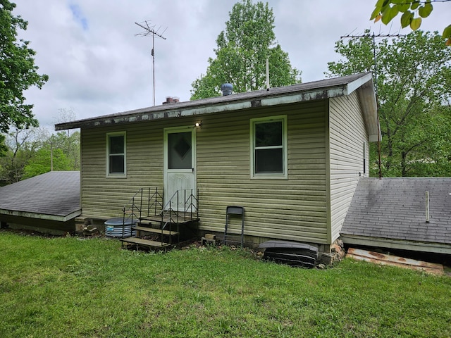 rear view of property featuring a lawn