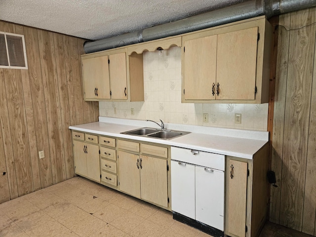 kitchen with sink, a textured ceiling, wooden walls, backsplash, and light brown cabinetry