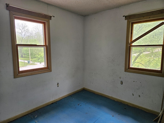 unfurnished room with a textured ceiling