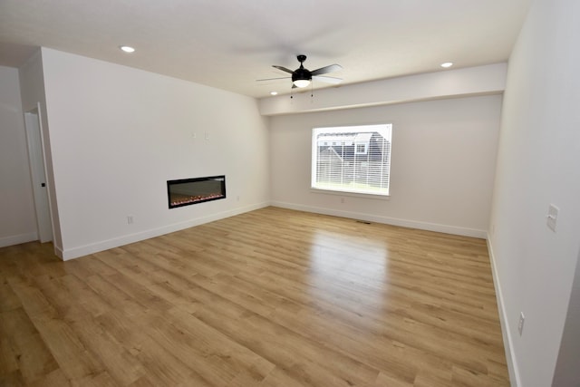 unfurnished living room with ceiling fan and light hardwood / wood-style flooring