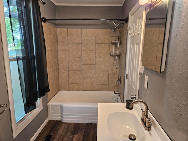 bathroom featuring crown molding, hardwood / wood-style floors, sink, and tiled shower / bath