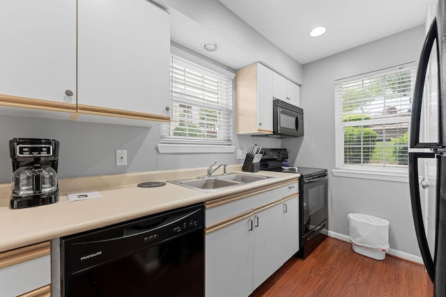 kitchen with white cabinets, black appliances, sink, and a wealth of natural light