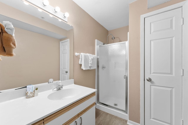 bathroom with a shower with door, vanity, and wood-type flooring