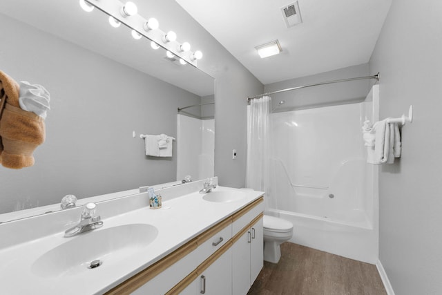 full bathroom with hardwood / wood-style floors, shower / bath combo, vanity, and toilet