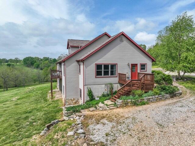 view of front of house with a deck and a front lawn