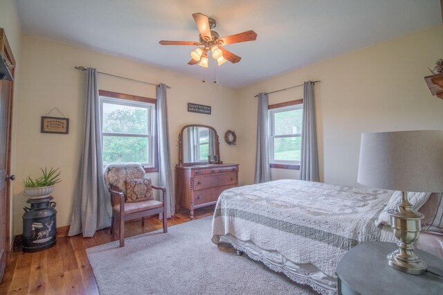 bedroom featuring light hardwood / wood-style flooring, multiple windows, and ceiling fan