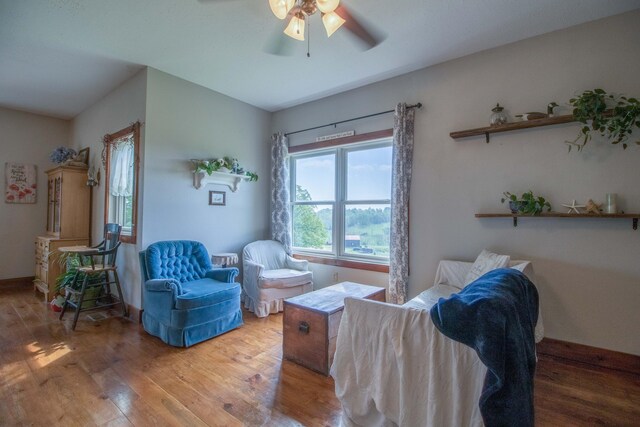 living area with hardwood / wood-style floors and ceiling fan