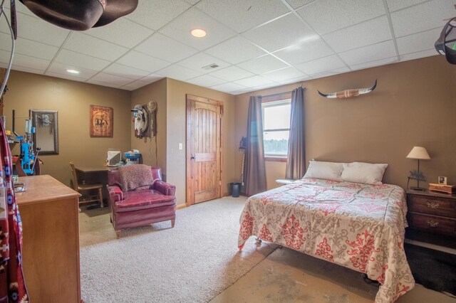 carpeted bedroom featuring a drop ceiling