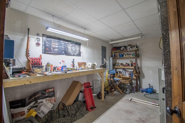 basement featuring a drop ceiling and a workshop area