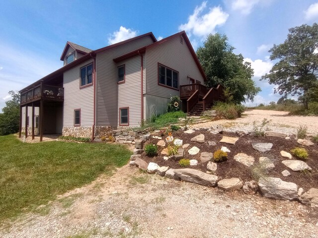 view of side of property with a wooden deck and a lawn