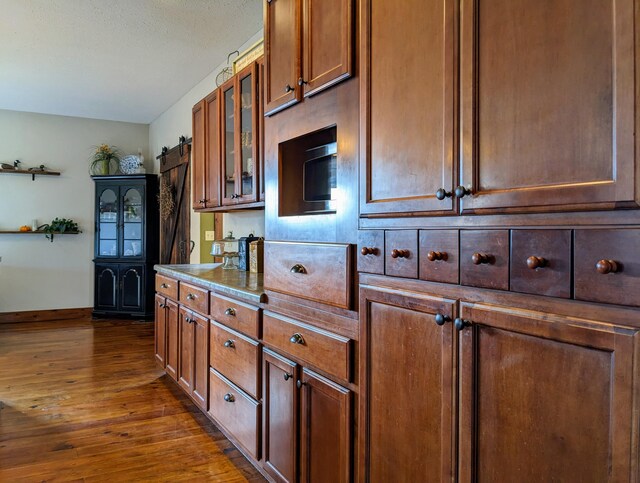 kitchen with dark wood-type flooring and a barn door